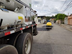 Rolo compactador nivelando a rua no serviço de tapa-buracos
