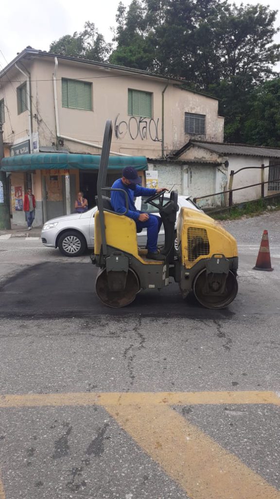 Máquina de compactação de solo nivelando rua na cidade no serviço de tapa-buracos