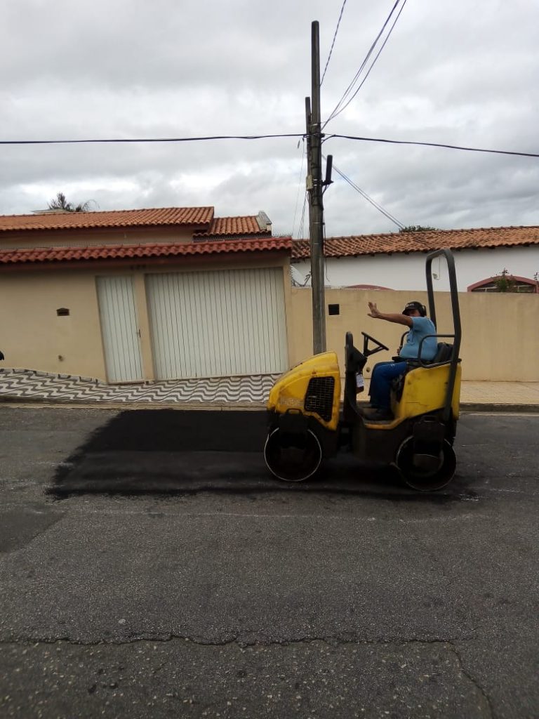 Máquina de nivelamento de asfalto sendo guiada para execução de tapa-buracos