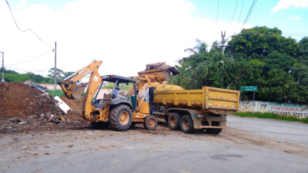 Retroescavadeira e caminhão com entulho oriundo da limpeza de área pública